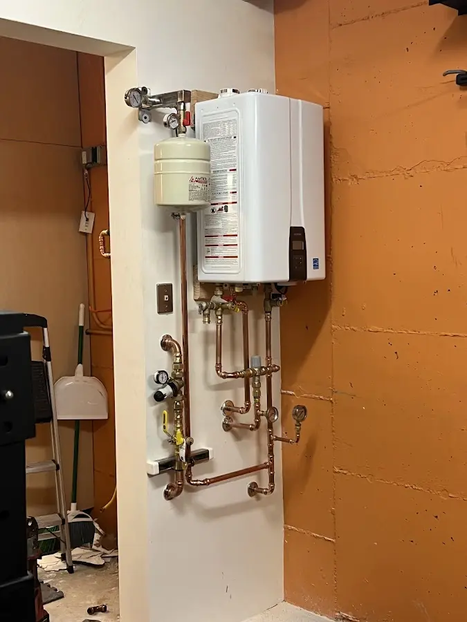 Plumbing technician inspecting water heater connections in Leon Valley